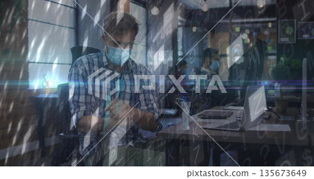 Man wearing shirt and mask applying hand sanitizer at office desk, with laptop and code overlay Man wearing shirt and mask applying hand sanitizer at office desk, with laptop and code overlay 135673649