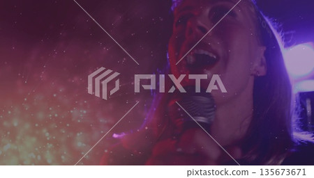 Singing performer wearing crown projecting vocals on stage, with microphone, haze, copy space Singing performer wearing crown projecting vocals on stage, with microphone, haze, copy space 135673671