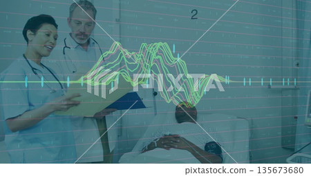Female nurse in blue scrubs reviewing patient chart with doctor at hospital bed, with ECG overlay 135673680