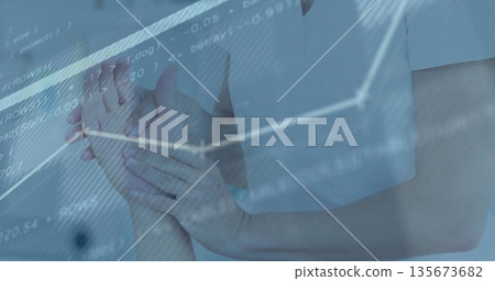 Supporting clinician wearing white scrub holding patient's wrist in clinic, with digital overlays 135673682