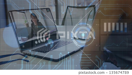 Displaying laptop showing woman wearing blazer taking notes in office, with pen papers and graphics Displaying laptop showing woman wearing blazer taking notes in office, with pen papers and graphics 135674789
