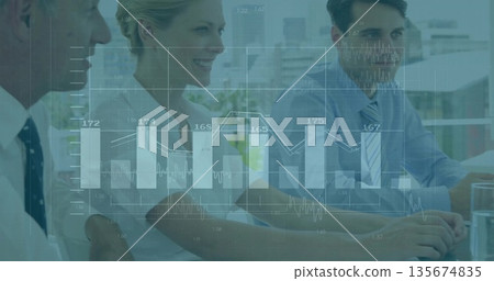 Group analyzing digital overlay bar and line charts in meeting room, with laptops and water glasses 135674835