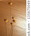 Small yellow flowers and shadows of life on a wooden table 135675049