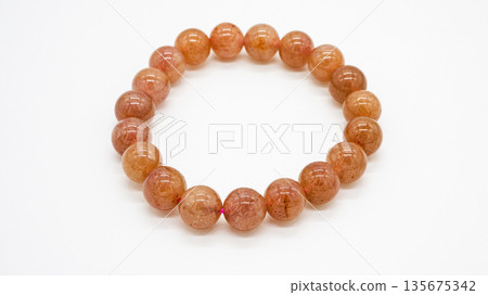 Strawberry quartz bracelet macro shot on white background Strawberry quartz bracelet macro shot on white background 135675342