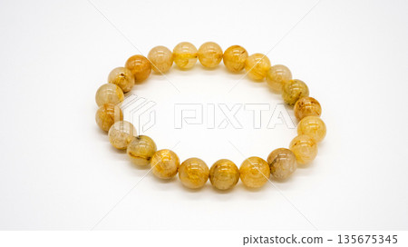 Gold rutilated quartz bracelet, macro photography, white background Gold rutilated quartz bracelet, macro photography, white background 135675345