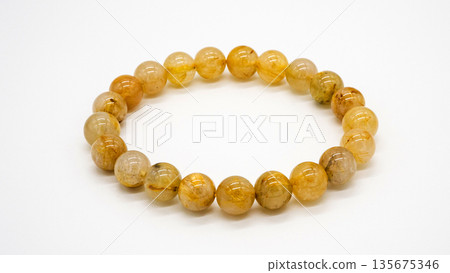 Gold rutilated quartz bracelet, macro photography, white background Gold rutilated quartz bracelet, macro photography, white background 135675346