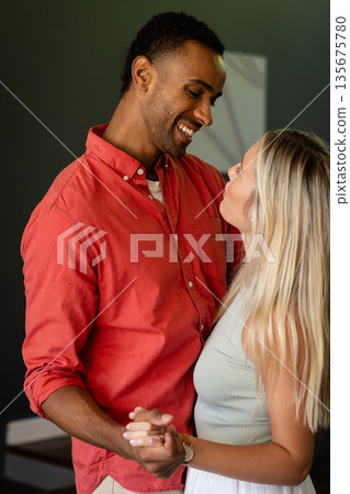 Couple dancing closely at home, sharing joyful smiles and tender moments Couple dancing closely at home, sharing joyful smiles and tender moments 135675780