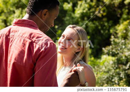 Couple holding hands outdoors, smiling and enjoying sunny day together Couple holding hands outdoors, smiling and enjoying sunny day together 135675791