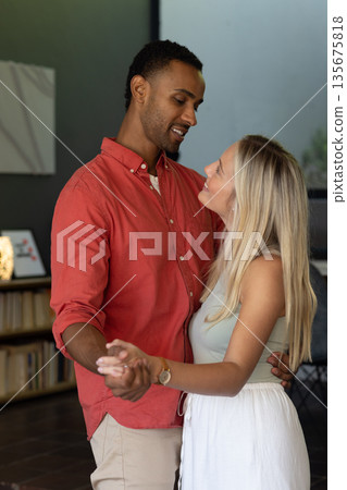 Couple dancing closely at home, sharing joyful moments and smiling warmly 135675818