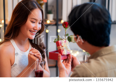 Romantic asian man giving gift box to girlfriend with excited, surprise for Valentine's Day. Romantic asian man giving gift box to girlfriend with excited, surprise for Valentine's Day. 135675942