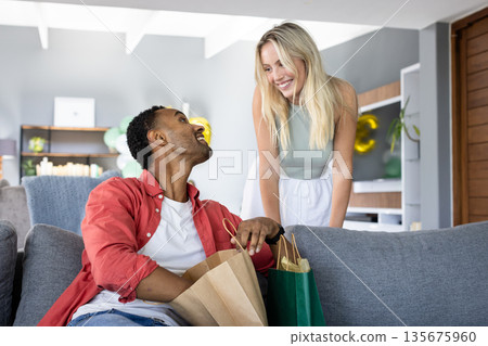 Couple enjoying shopping together at home, sharing joyful smiles and conversation 135675960