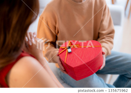 Happy asian man giving heart gift box to girlfriend celebrating Valentine's Day or anniversary. Happy asian man giving heart gift box to girlfriend celebrating Valentine's Day or anniversary. 135675962
