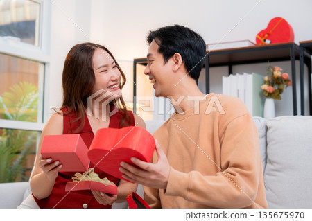 Romantic asian couple giving and receiving heart gift box for celebrating birthday or holiday. Romantic asian couple giving and receiving heart gift box for celebrating birthday or holiday. 135675970