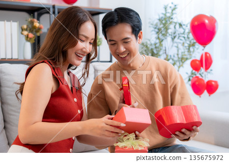 Romantic asian couple giving and receiving heart gift box for celebrating birthday or holiday. 135675972