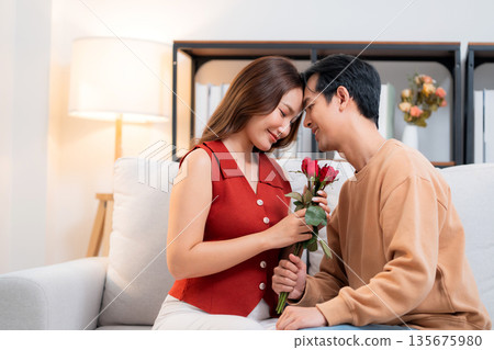 Happy asian woman receiving rose bouquet from boyfriend with celebrating Valentine's Day. Happy asian woman receiving rose bouquet from boyfriend with celebrating Valentine's Day. 135675980