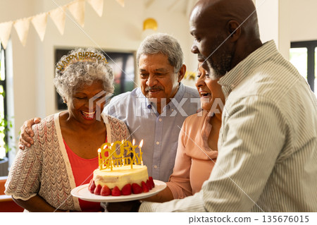 Celebrating birthday, African American family with cake, smiling happily together 135676015