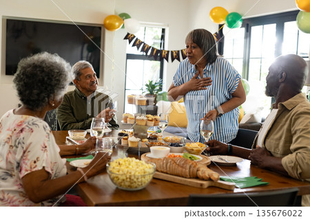 African American family enjoying festive meal with drinks and snacks at home African American family enjoying festive meal with drinks and snacks at home 135676022