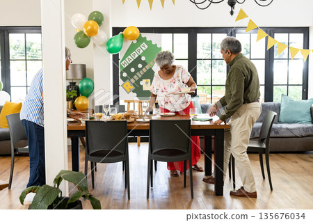 Family preparing festive table for retirement party with decorations and balloons Family preparing festive table for retirement party with decorations and balloons 135676034