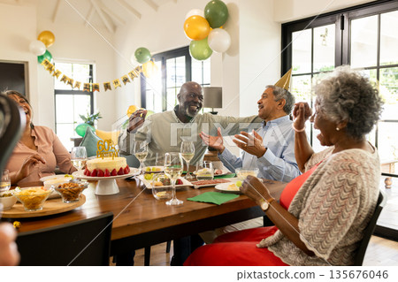 Celebrating birthday with cake, family laughing and enjoying decorations together 135676046