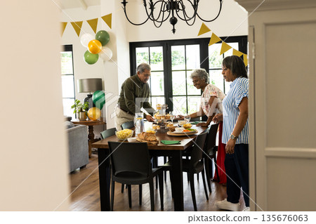 Family preparing festive meal together in dining room, setting table with joy 135676063