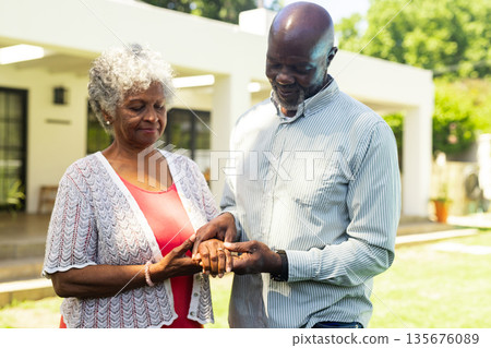 Elderly couple exchanging rings outdoors, celebrating love and commitment together Elderly couple exchanging rings outdoors, celebrating love and commitment together 135676089