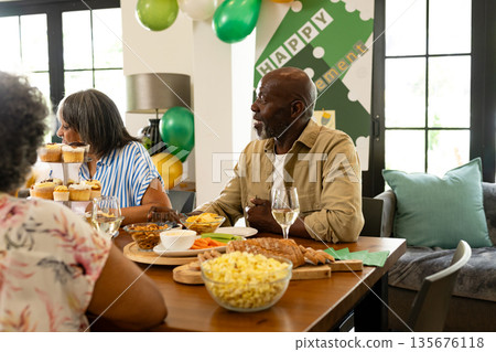 Celebrating retirement, African American family with snacks and drinks at home 135676118