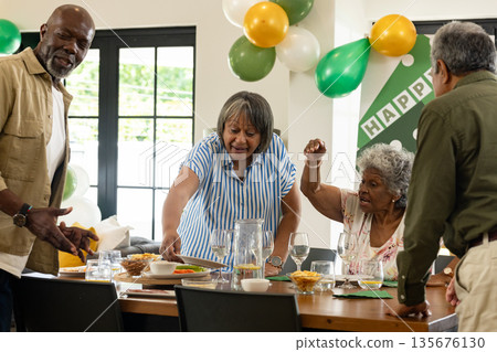 Celebrating at home, African American family sharing festive meal with laughter Celebrating at home, African American family sharing festive meal with laughter 135676130