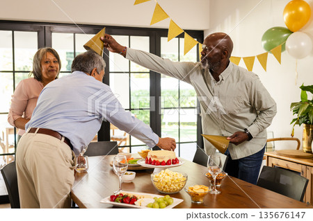 Decorating table with snacks and drinks, friends sharing laughter at party 135676147