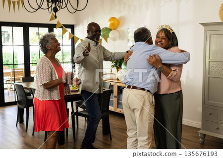 Family celebrating birthday at home, hugging and smiling with decorations around Family celebrating birthday at home, hugging and smiling with decorations around 135676193