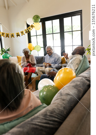 Family celebrating birthday at home, laughing and enjoying conversation on sofa 135676211