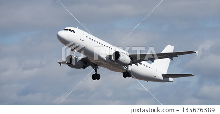 Airplane take off on the blue sky, with white clouds. Aircraft flying on sky background. White passenger jet plane in the blue sky. Low angle view of Airplane flying under blue sky, with white clouds Airplane take off on the blue sky, with white clouds. Aircraft flying on sky background. White passenger jet plane in the blue sky. Low angle view of Airplane flying under blue sky, with white clouds 135676389