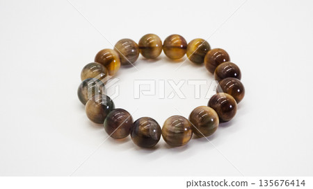 Tiger's eye bracelet, macro shot, white background Tiger's eye bracelet, macro shot, white background 135676414