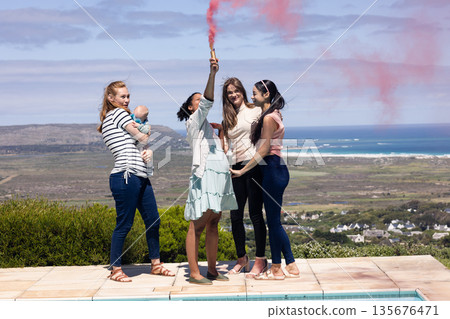 Friends celebrating with smoke flare by poolside, enjoying scenic ocean view Friends celebrating with smoke flare by poolside, enjoying scenic ocean view 135676471