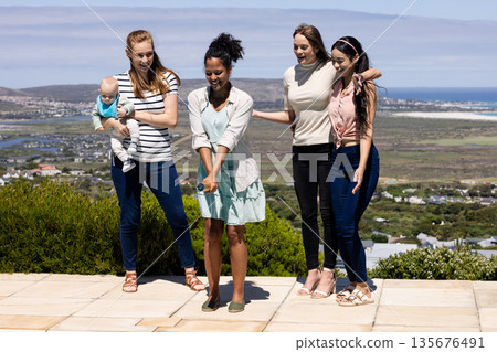 Group of women enjoying outdoor celebration, smiling and posing with baby Group of women enjoying outdoor celebration, smiling and posing with baby 135676491
