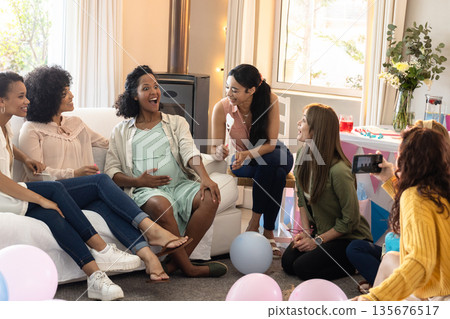 African American woman surrounded by friends celebrating baby shower at home African American woman surrounded by friends celebrating baby shower at home 135676517