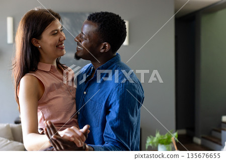 Couple embracing and smiling at home, enjoying joyful and intimate moment together Couple embracing and smiling at home, enjoying joyful and intimate moment together 135676655