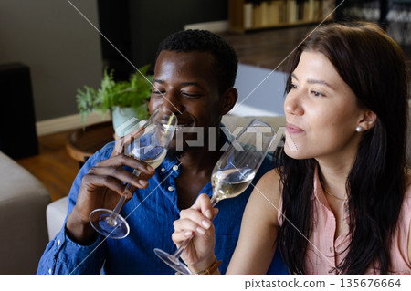Couple enjoying champagne together at home, celebrating with joyful expressions 135676664