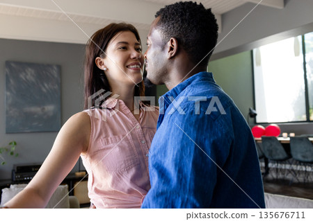 Couple embracing and smiling at home, enjoying joyful moment together 135676711