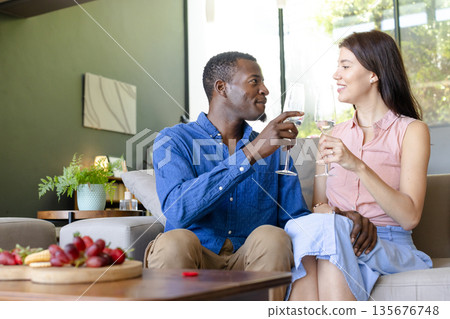 Couple enjoying wine together at home, celebrating with smiles and conversation Couple enjoying wine together at home, celebrating with smiles and conversation 135676748