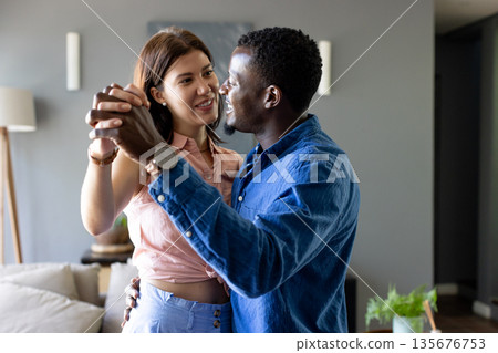 Dancing happily at home, couple sharing joyful moment together Dancing happily at home, couple sharing joyful moment together 135676753