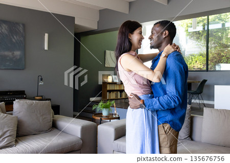 Couple embracing and smiling at home, enjoying joyful moment together 135676756