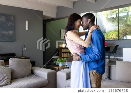 Couple embracing lovingly in modern living room, sharing joyful moment together Couple embracing lovingly in modern living room, sharing joyful moment together 135676758