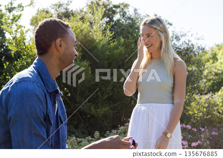 Man proposing to surprised woman in garden, creating joyful and romantic moment Man proposing to surprised woman in garden, creating joyful and romantic moment 135676885