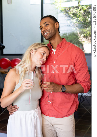 Couple celebrating at home, holding champagne glasses and enjoying moment 135676895