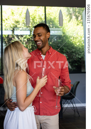 Celebrating with champagne, African American man and woman smiling in conversation Celebrating with champagne, African American man and woman smiling in conversation 135676906