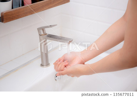 Closeup hands in sink with foaming soap, feeling hygienic and refreshed for prevention virus spread. Closeup hands in sink with foaming soap, feeling hygienic and refreshed for prevention virus spread. 135677011