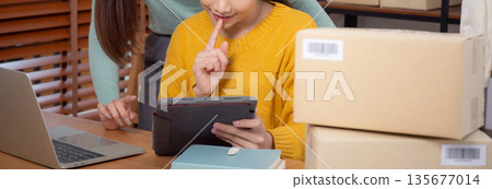Two young asian woman working on tablet while managing and planning online business. 135677014