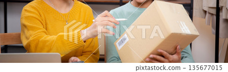 Two asian woman working while planning online business and checking order with writing on tablet. Two asian woman working while planning online business and checking order with writing on tablet. 135677015