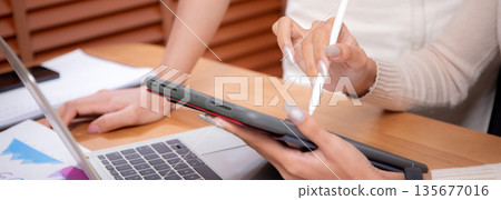 Closeup hand of two young asian businesswoman planning and strategy about marketing and financial. 135677016