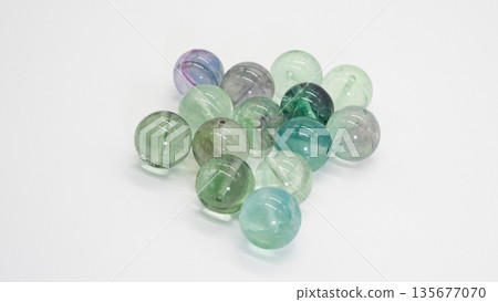 Rainbow fluorite natural stone beads macro photography white background 135677070